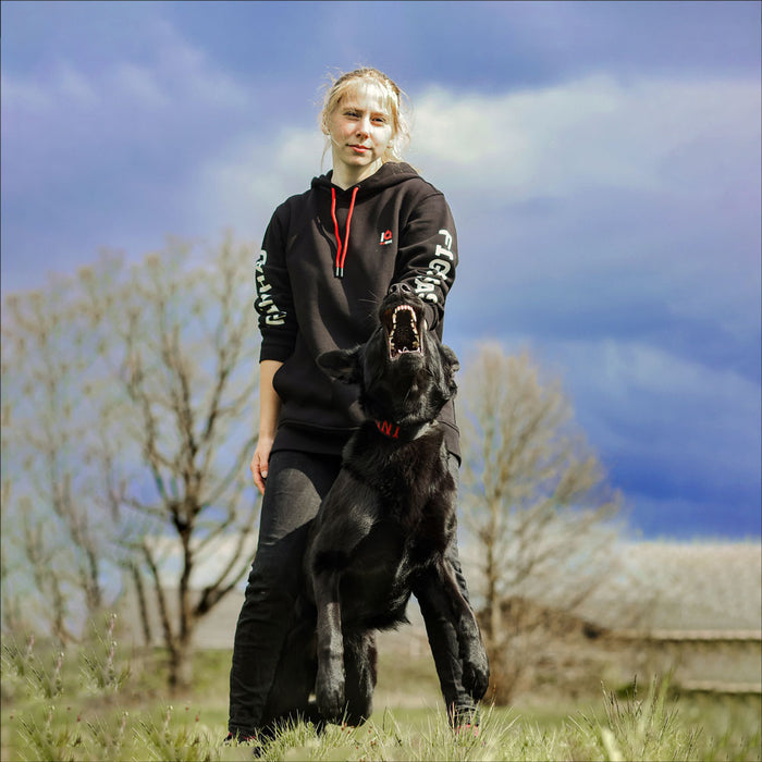 Hundeführer mit schwarzem Schäferhund im Train Hard Fight Easy Trainings-Hoodie